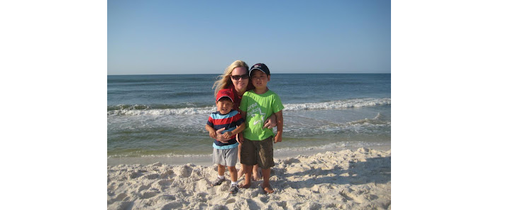 Two smiling adopted children standing with their mother on a beach